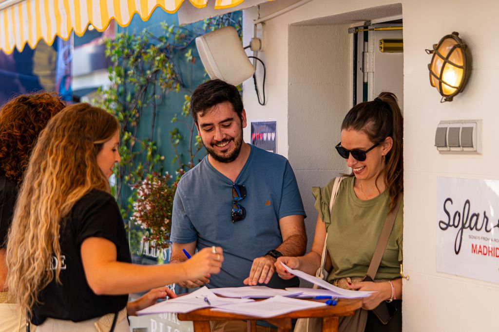 People signing up for an event outdoors, creating a lively atmosphere.